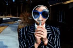 Suited man looking through magnifying glass