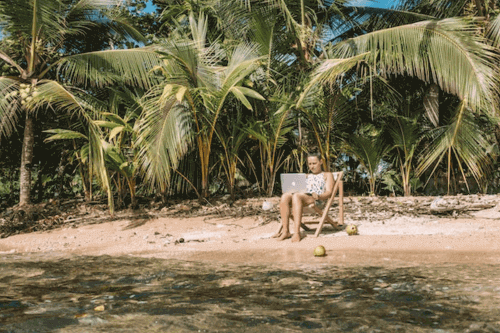 Woman working on her laptop on a beach