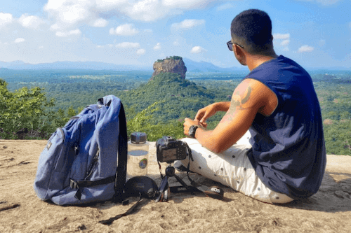 Best Travel Water Bottles - Man sitting on a mountain